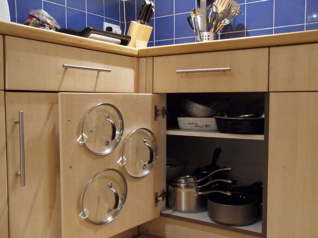 Hang pot and pan lids on the cabinet door by using adhesive hooks