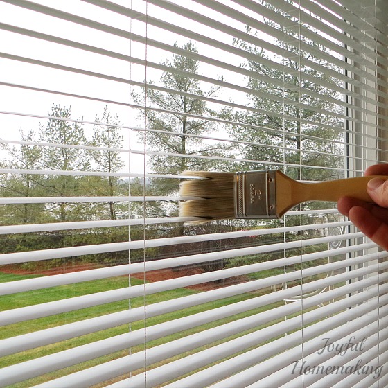 Use a paintbrush to clean blinds